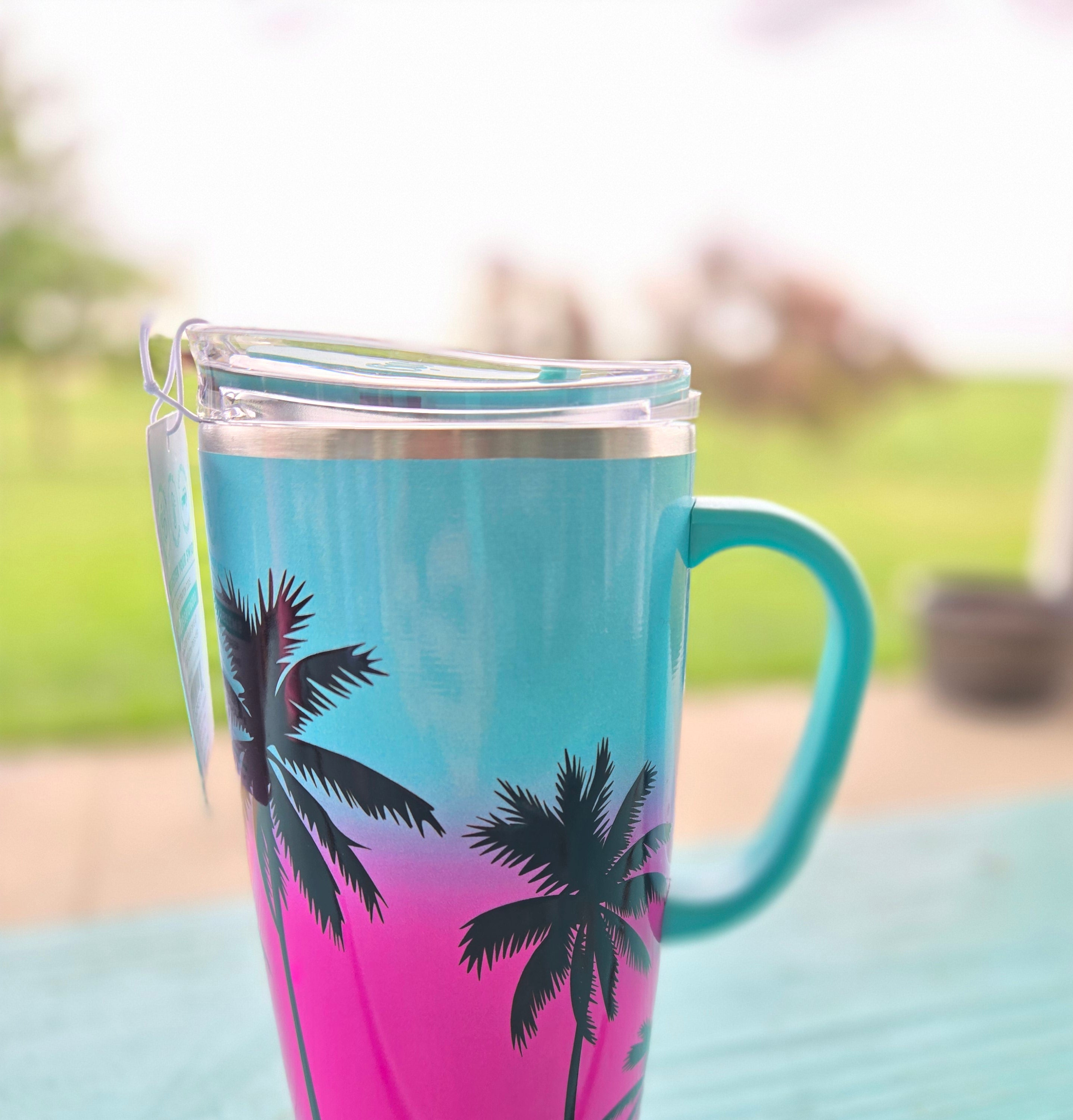 Gradient mug with SWIG palm tree design on a blurred background