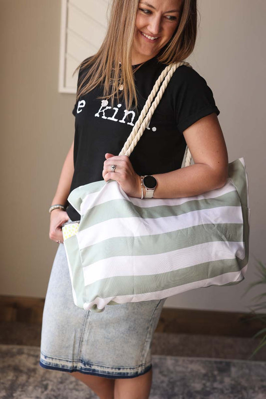 Introducing the Green Striped Rope Handle Tote Bag - your go-to bag for any summer outing! Effortlessly shake out sand or crumbs with the slick inside lining. Stay organized with big side pockets and a zipper top. Plus, the adorable beach rope handles add a touch of charm. Classy Closet Hull Iowa Boutique