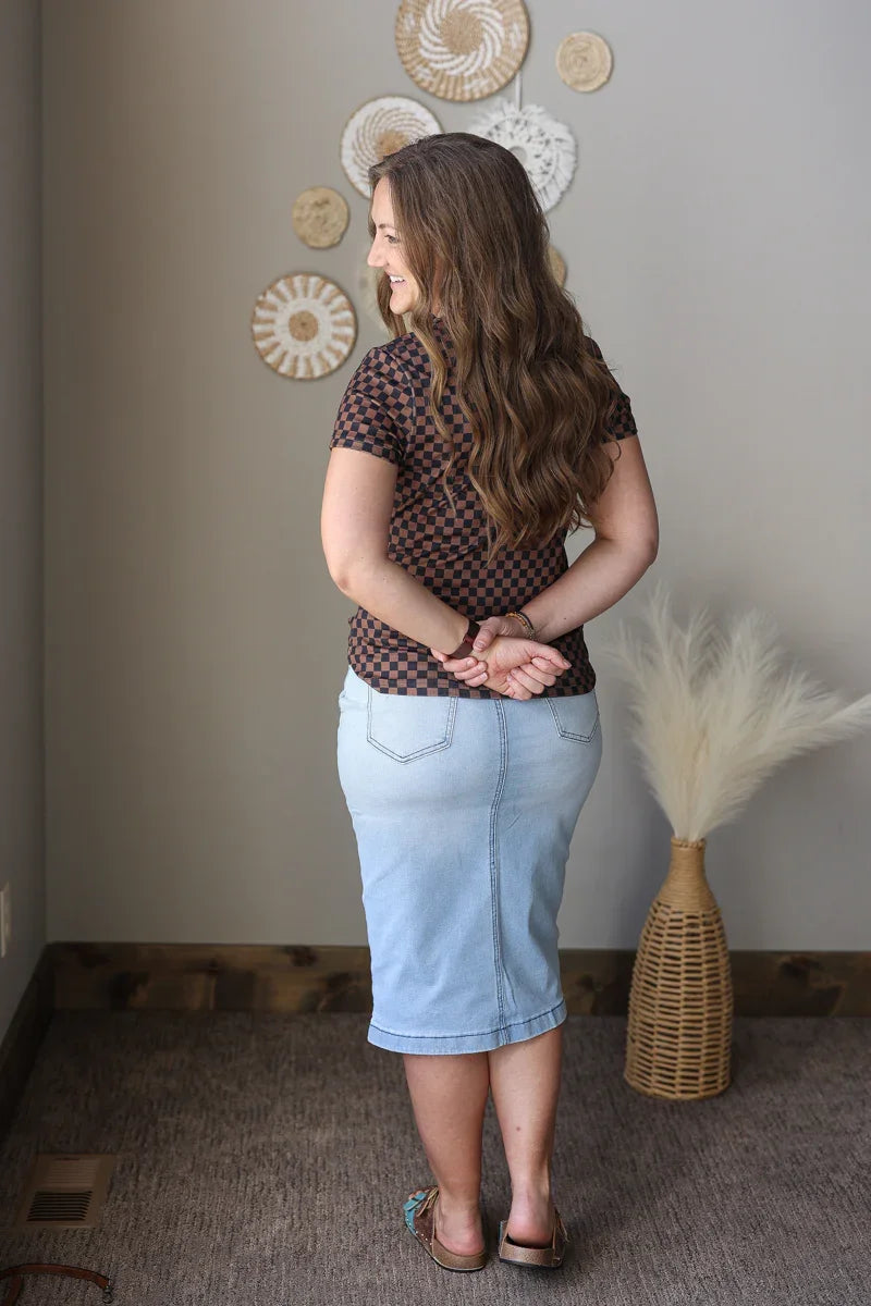 Woman standing in a room with decorative wall art and a vase.