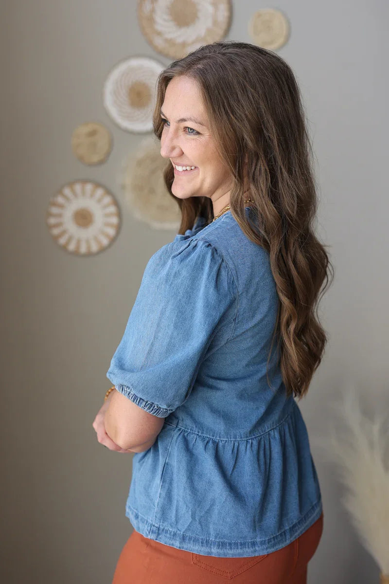 Woman wearing a blue blouse with a neutral background