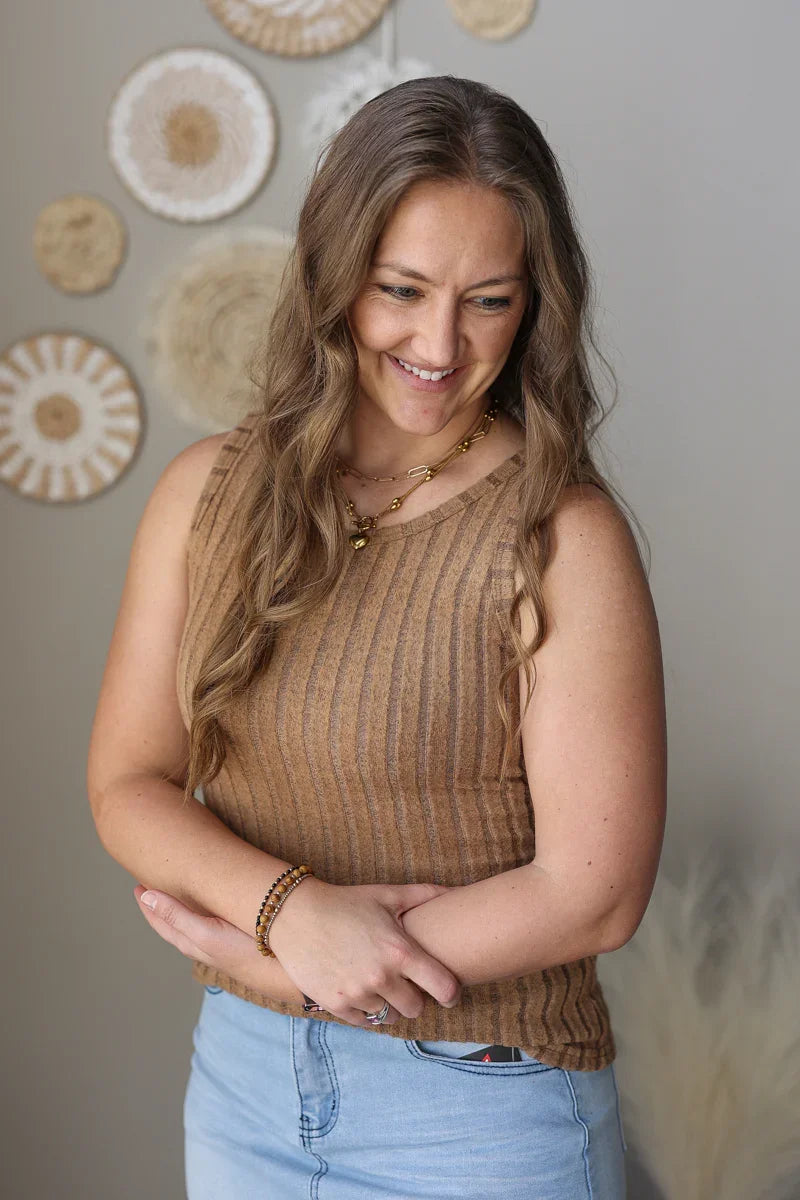 woman wearing a slim fit brown ribbed sleeveless tank top for summer with denim skirt