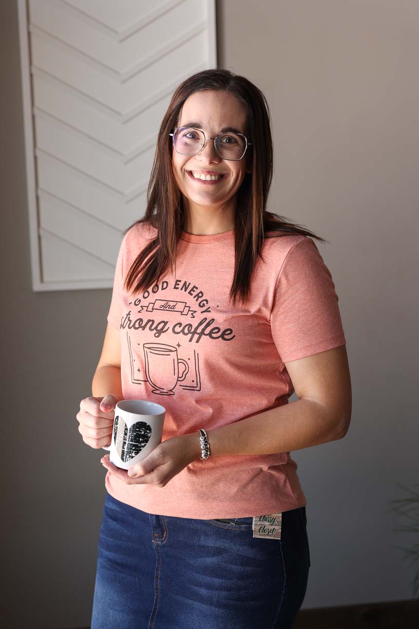 Start your day with a smile in our Heather Sunset "Good Energy Strong Coffee" Tee. As a mama, you know the importance of positive vibes, so why not style it with this slim-fit, graphic tee. Comfy and stylish, it's the perfect mantra for any mom on the go.
We recommend sizing up as this is a slim-fit cut Bella Canvas tee. Classy Closet Hull Iowa online women's clothing boutique for modest fashion, cute mom outfits, spring summer 2025 trends. Cute, modest, affordable women's tops.