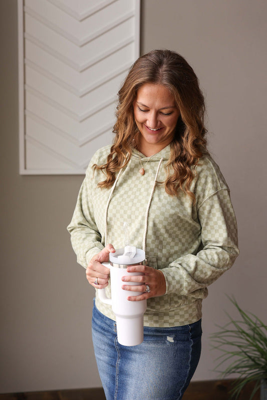 Stay stylish and comfortable with our Mint Checkered Kangaroo Pocket Hoodie! Made from a soft and light-medium weight material, this sweatshirt is perfect for any season. The subtle checkered design adds a touch of charm, making you feel cozy and chic at the same time. Get ready to be obsessed with this must-have piece! Classy Closet online women's clothing boutique for trendy, cute tops and modest fashion by Hull iowa.