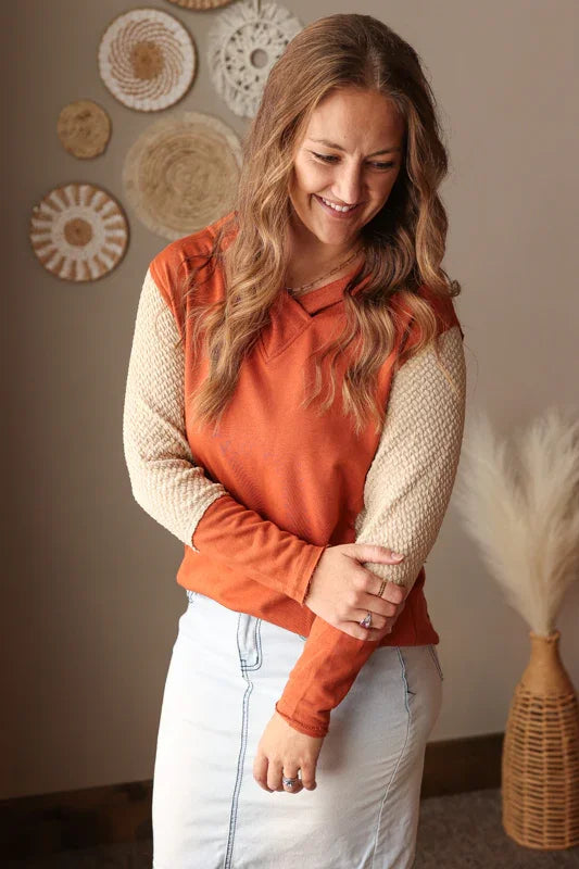 Woman wearing a chestnut orange colorblock sleeve v-neck hooded top for casual mom life
