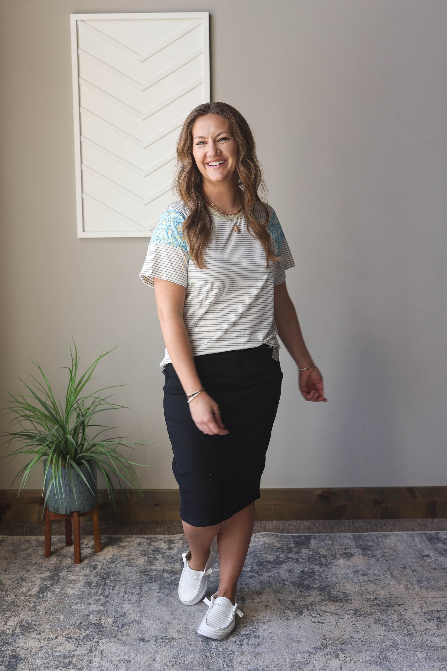 Introducing our White Stripe Floral Insert Sleeve Top. Made from a combination of white and grey stripes, this top features a beautiful blue floral insert on the sleeve. Perfect for easy, feminine style at home or on the go - whether you're working, strolling in the park, or more!