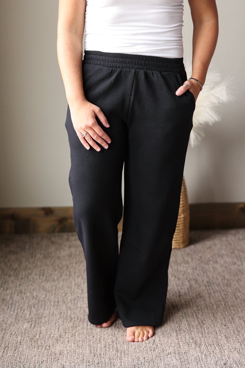 solid black elastic waist sweatpants with fleece inside, pockets, and wide straight leg for all day comfort