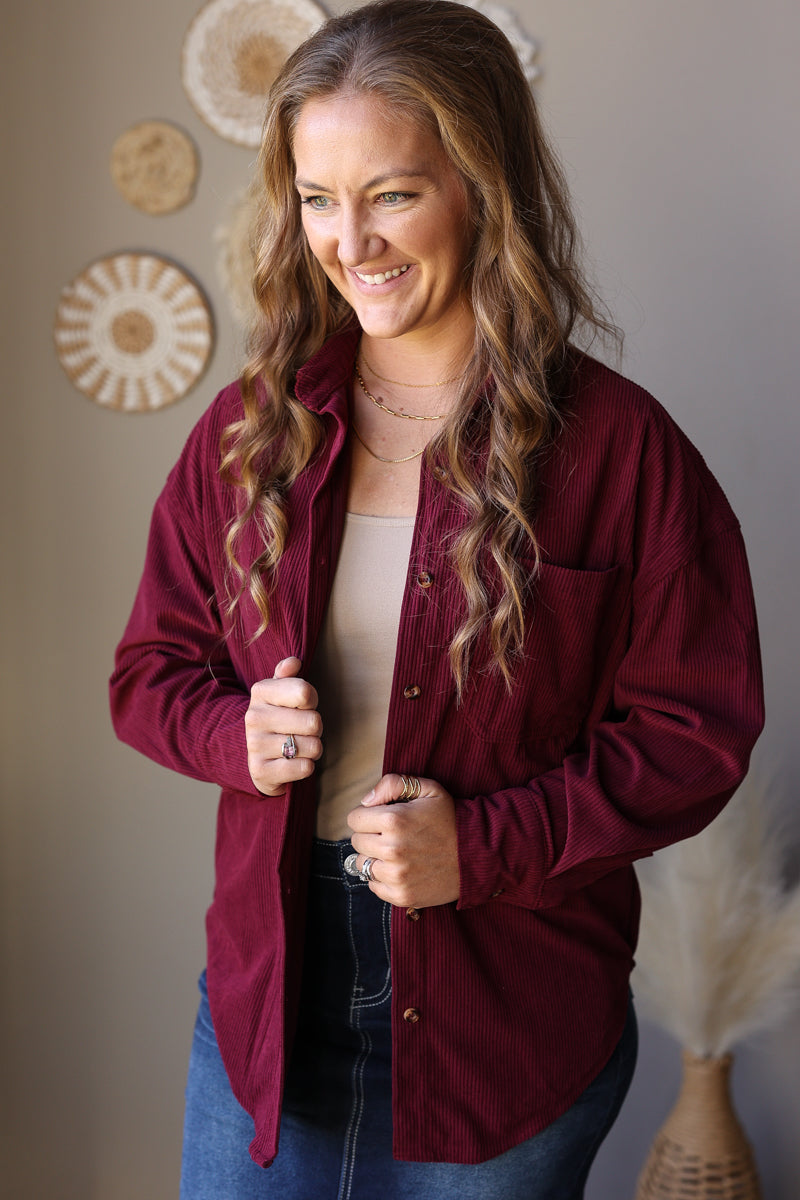 Wine corduroy shirt worn open, showing the collar, button front, and long sleeves.