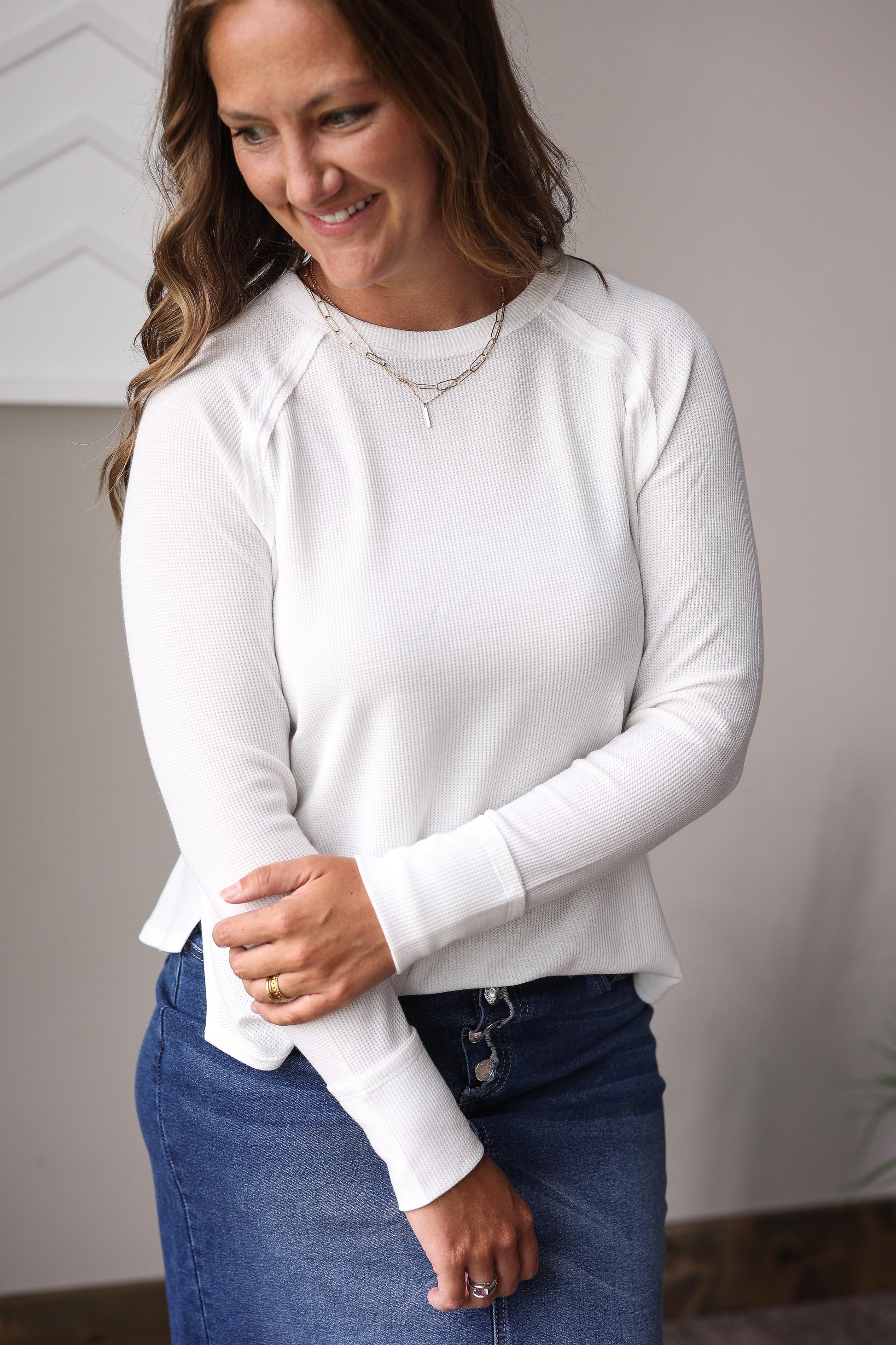 White waffle knit crew long sleeve top layered under denim jacket with plaid midi skirt.