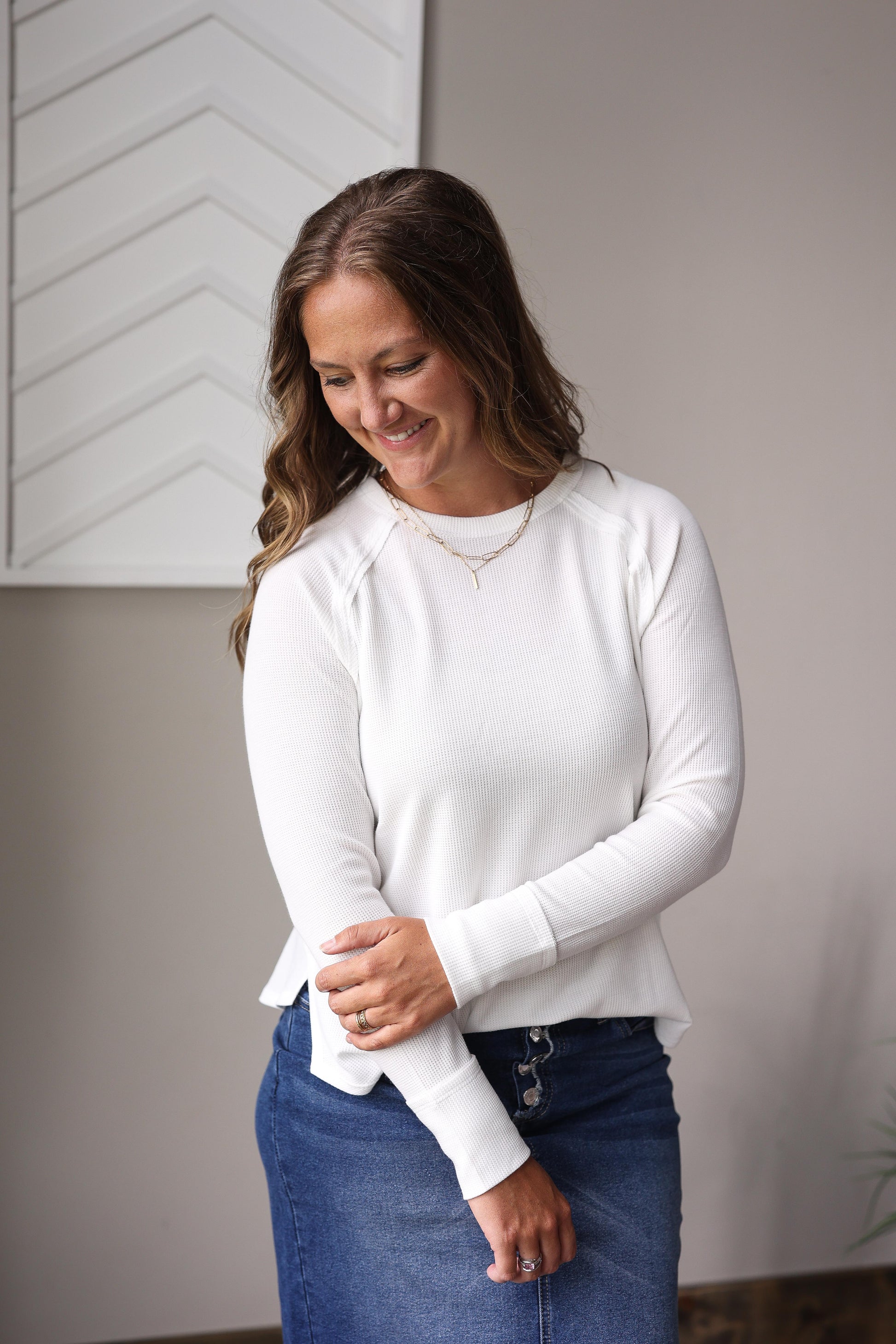 White waffle knit crew long sleeve top layered under denim jacket with plaid midi skirt.
