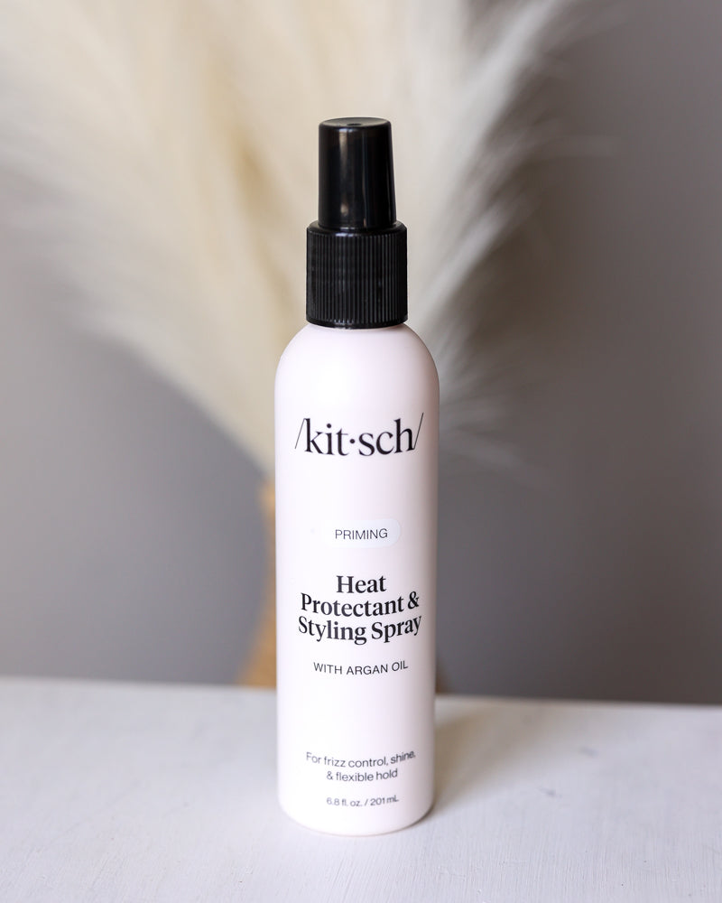 Kitsch heat protectant and styling spray bottle on a neutral background