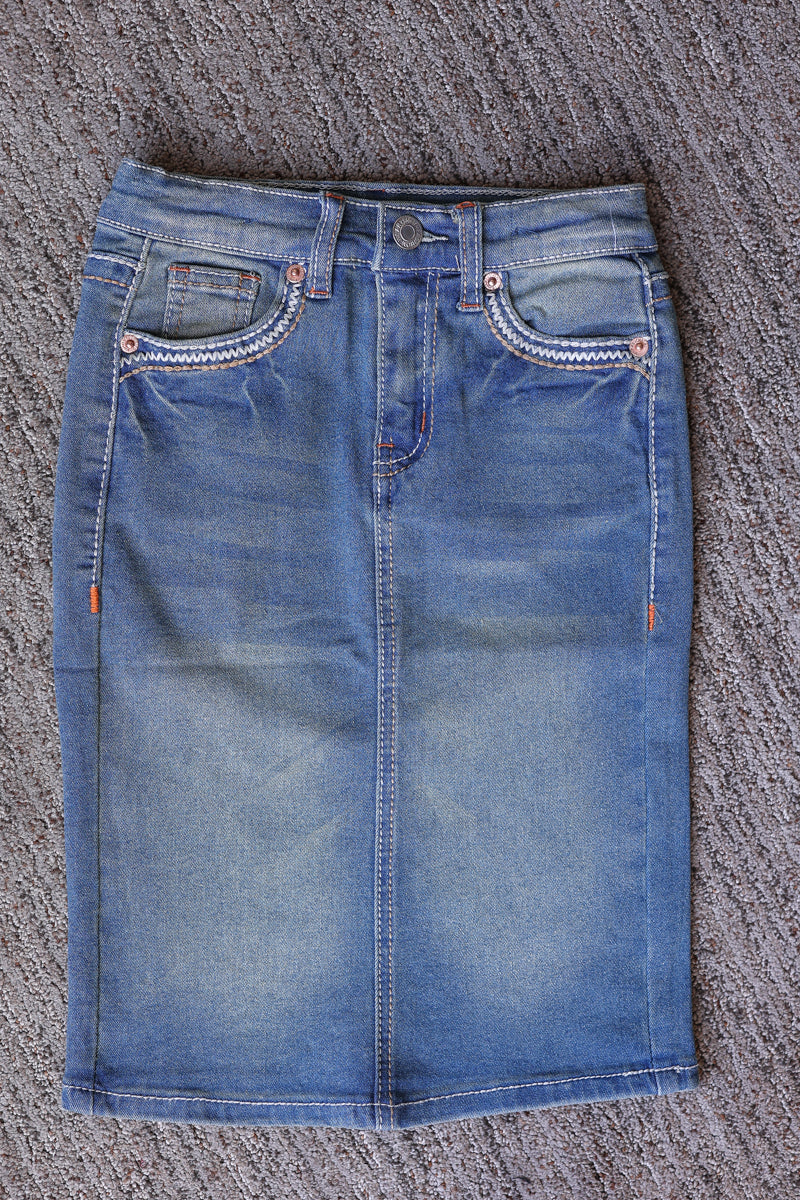 Front flat lay of a girls’ vintage wash denim midi skirt with faded blue denim, front pockets, belt loops, and a button waist.
