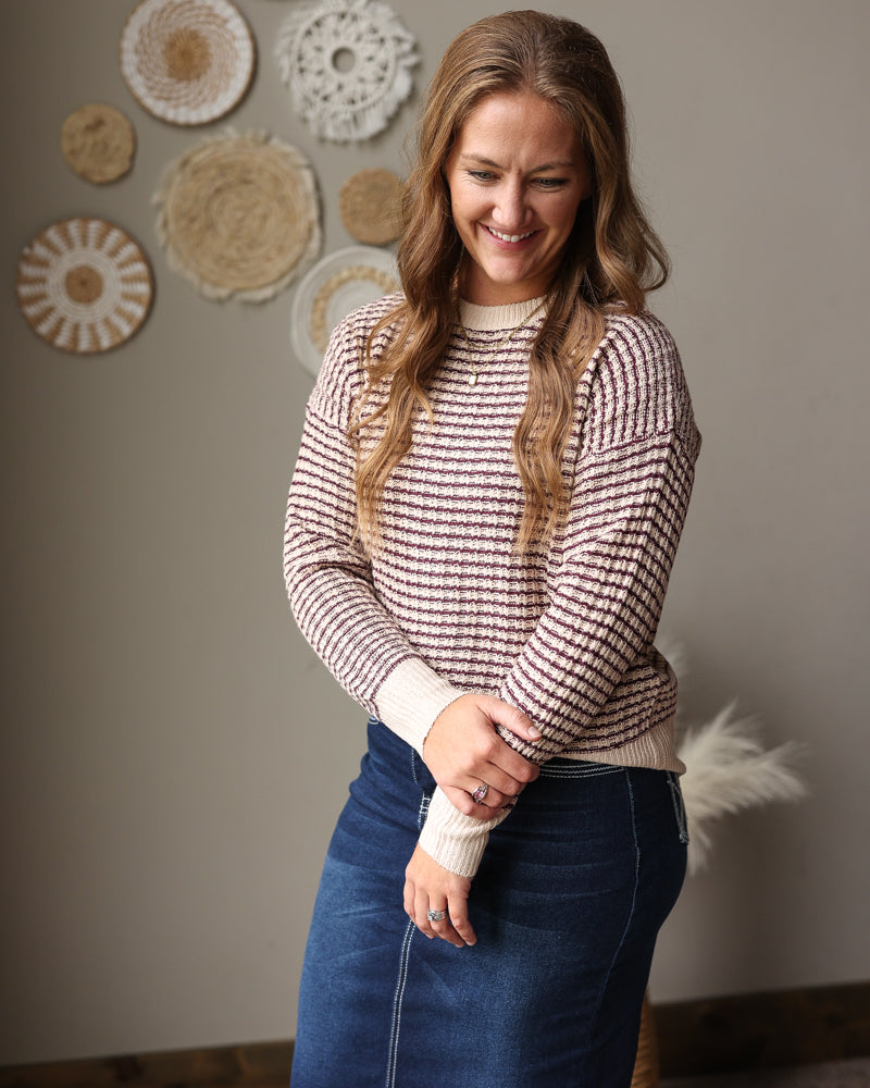 mocha and burgundy checkered staccato sweater styled with a dark wash stretch denim midi skirt