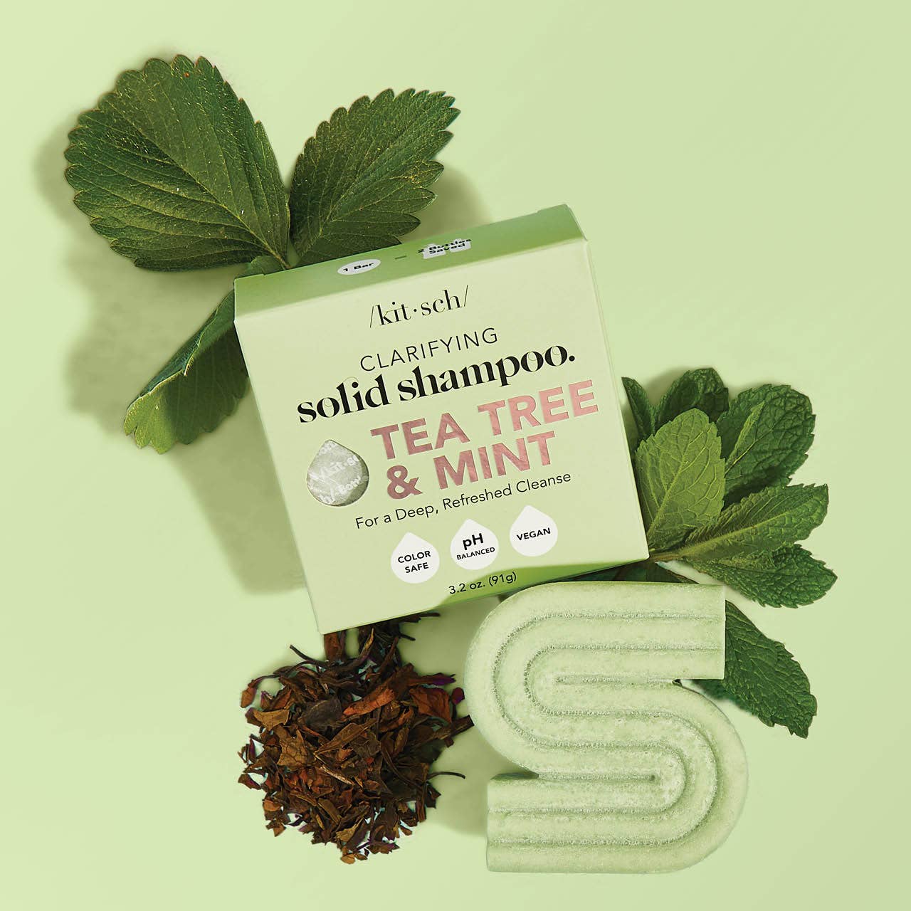 Kitsch clarifying solid shampoo bar with tea tree and mint on a green background