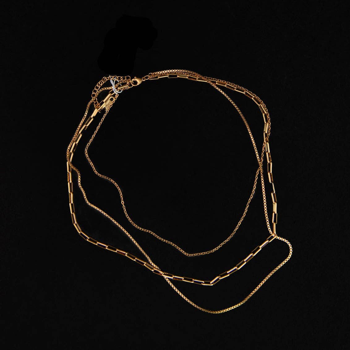 Gold chain necklace on a black background