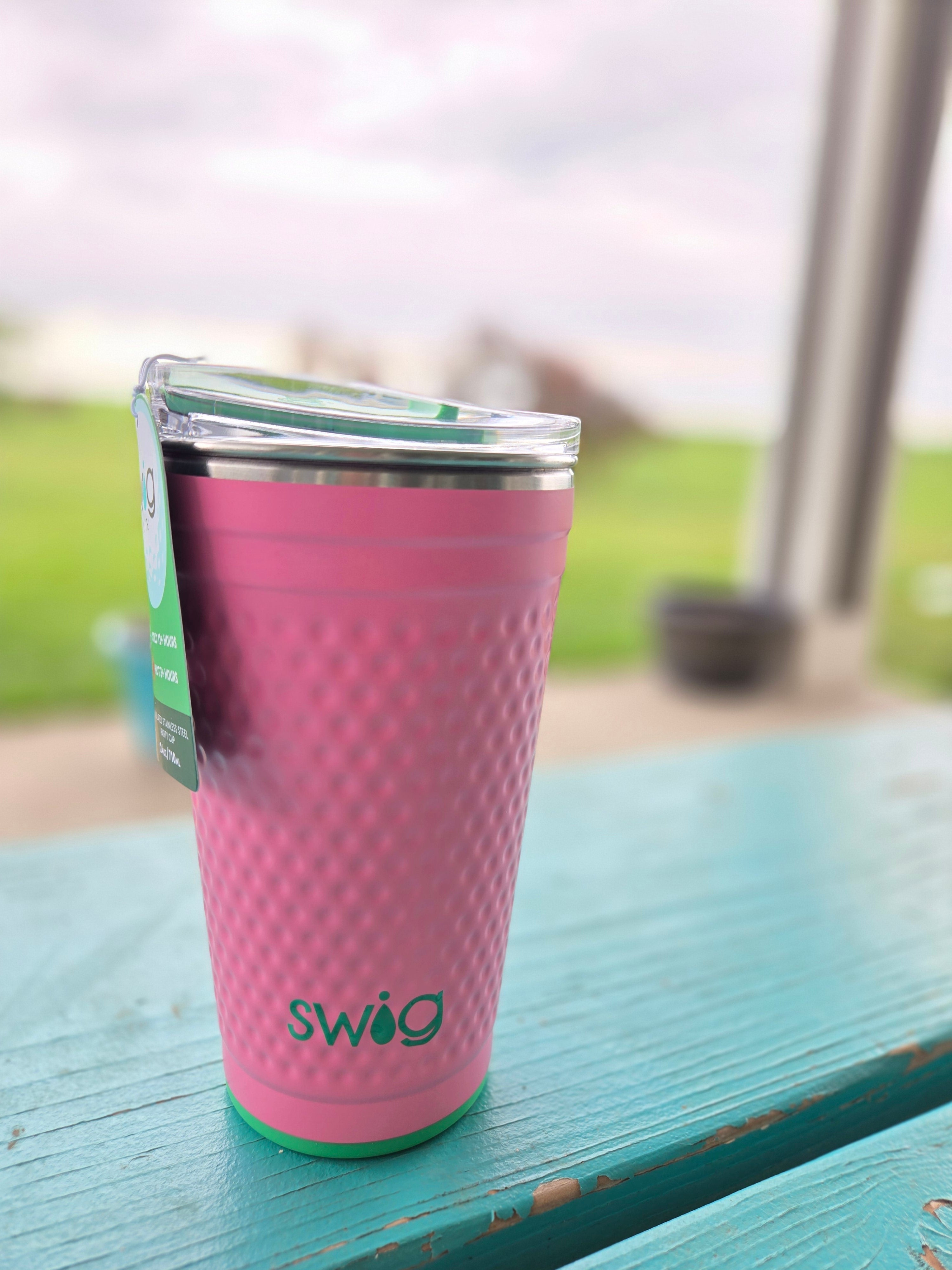 Pink textured bottle with 'swig' branding on a glass surface