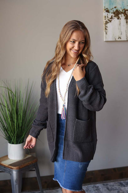 Stay cozy this season with this Ash Grey Waffle Cardigan. Perfect for bonfires, chilly morning coffee time, or just lounging around the house, its waffle knit and front pockets make it both stylish and warm. Classy Closet Modest Boutique Near Me