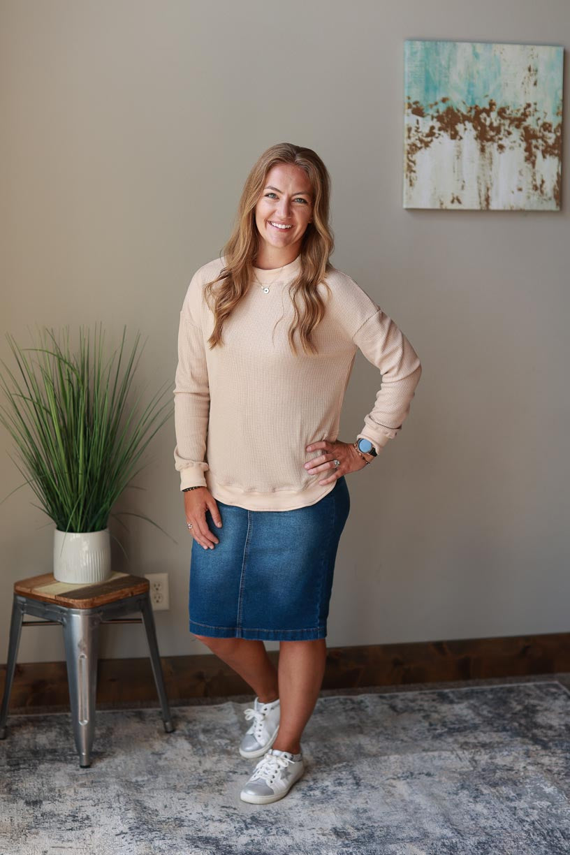 This beige crewneck top is the perfect blend of comfort and style. Its cozy, waffle sweatshirt-like feel is conveniently fashionable, and side slits add a chic finish. This top is ideal for those looking for an effortless yet sophisticated work style.