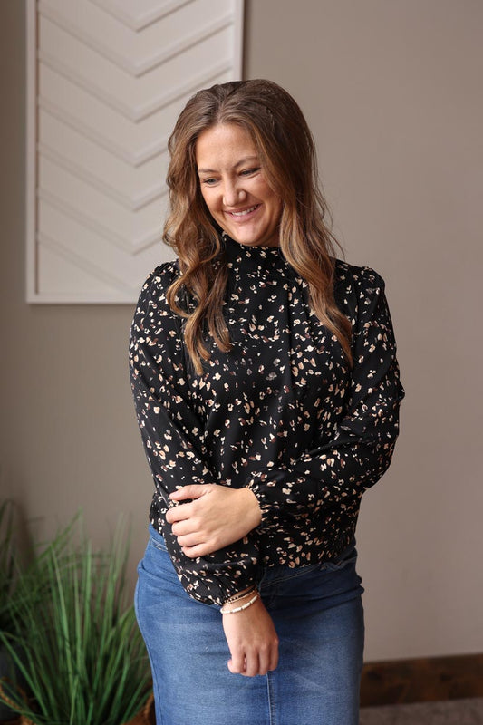 Introducing our Black Leopard Print Mock Neck Blouse, featuring a classy black, brown, and white dotted design. With a slight mock neck and pleat detail, it's perfect for the office, church, date nights, weddings, and more. The elastic sleeve cuff and keyhole neck closure add a chic and lightweight touch. Classy Closet online women's clothing boutique for women's chic outfits and modest fashion at affordable prices. Hull iowa