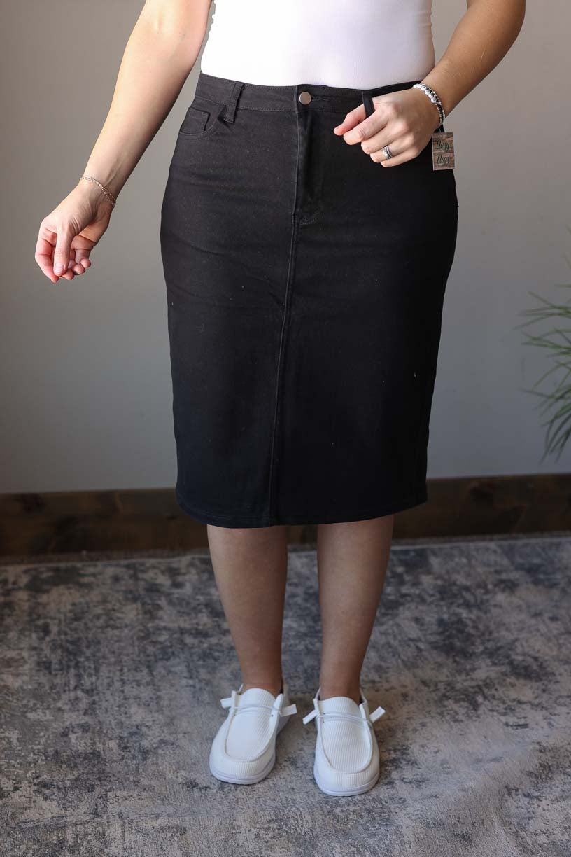 So excited to bring you our Stella Black Wash Knee Length Denim Skirt - the perfect addition to any wardrobe! Made with stretchy, solid black denim, this knee length skirt features a trendy back slit for a chic and comfortable fit. Add some color to your denim collection with this fun and stylish piece. Classy Closet online modest clothing for women, modest denim skirts, midi skirts, jean skirts, knee length skirts, Hull iowa