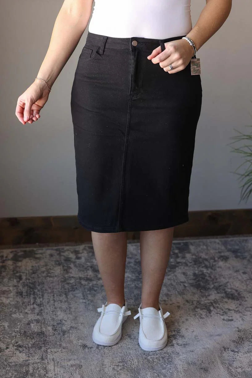 So excited to bring you our Stella Black Wash Knee Length Denim Skirt - the perfect addition to any wardrobe! Made with stretchy, solid black denim, this knee length skirt features a trendy back slit for a chic and comfortable fit. Add some color to your denim collection with this fun and stylish piece. Classy Closet online modest clothing for women, modest denim skirts, midi skirts, jean skirts, knee length skirts, Hull iowa
