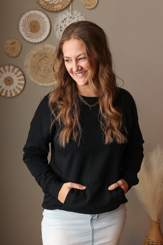Woman wearing Black Drop Shoulder Pocket Crewneck Sweatshirt with relaxed fit, casual style perfect for everyday comfort for spring style