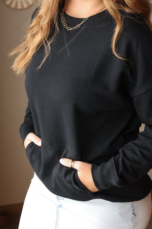 Woman wearing Black Drop Shoulder Pocket Crewneck Sweatshirt with relaxed fit, casual style perfect for everyday comfort for easy spring outfit