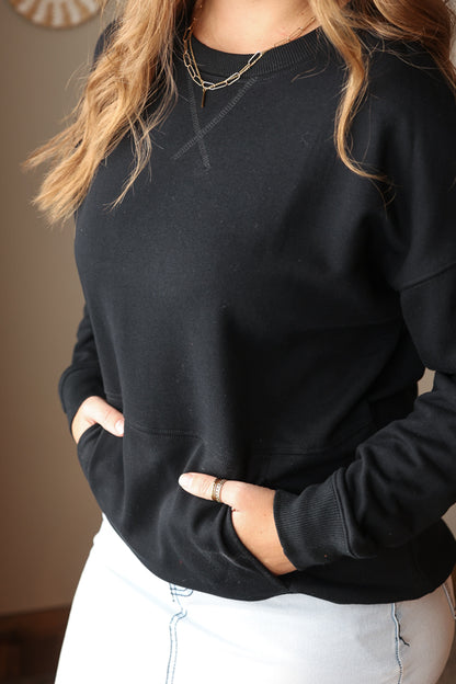 Woman wearing Black Drop Shoulder Pocket Crewneck Sweatshirt with relaxed fit, casual style perfect for everyday comfort for easy spring outfit
