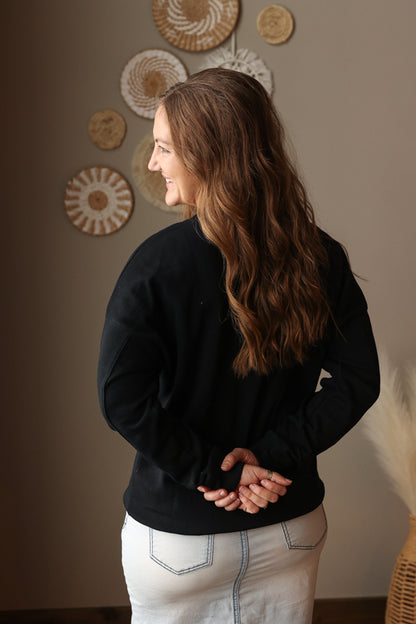 Woman wearing Black Drop Shoulder Pocket Crewneck Sweatshirt with relaxed fit, casual style perfect for everyday comfort for easy spring style