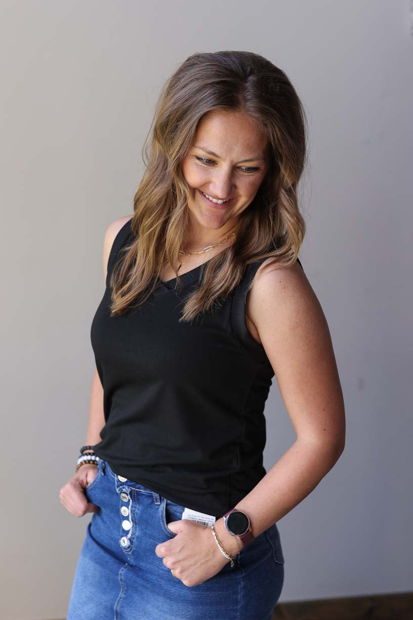 Upgrade your summer wardrobe with our Black Ribbed Tank! Whether you're headed to the park or the office, this versatile tank has got you covered. With its back coverage, wide sleeves, and non-low v-neck, it's perfect for any occasion. Get ready to make it your go-to top this season!