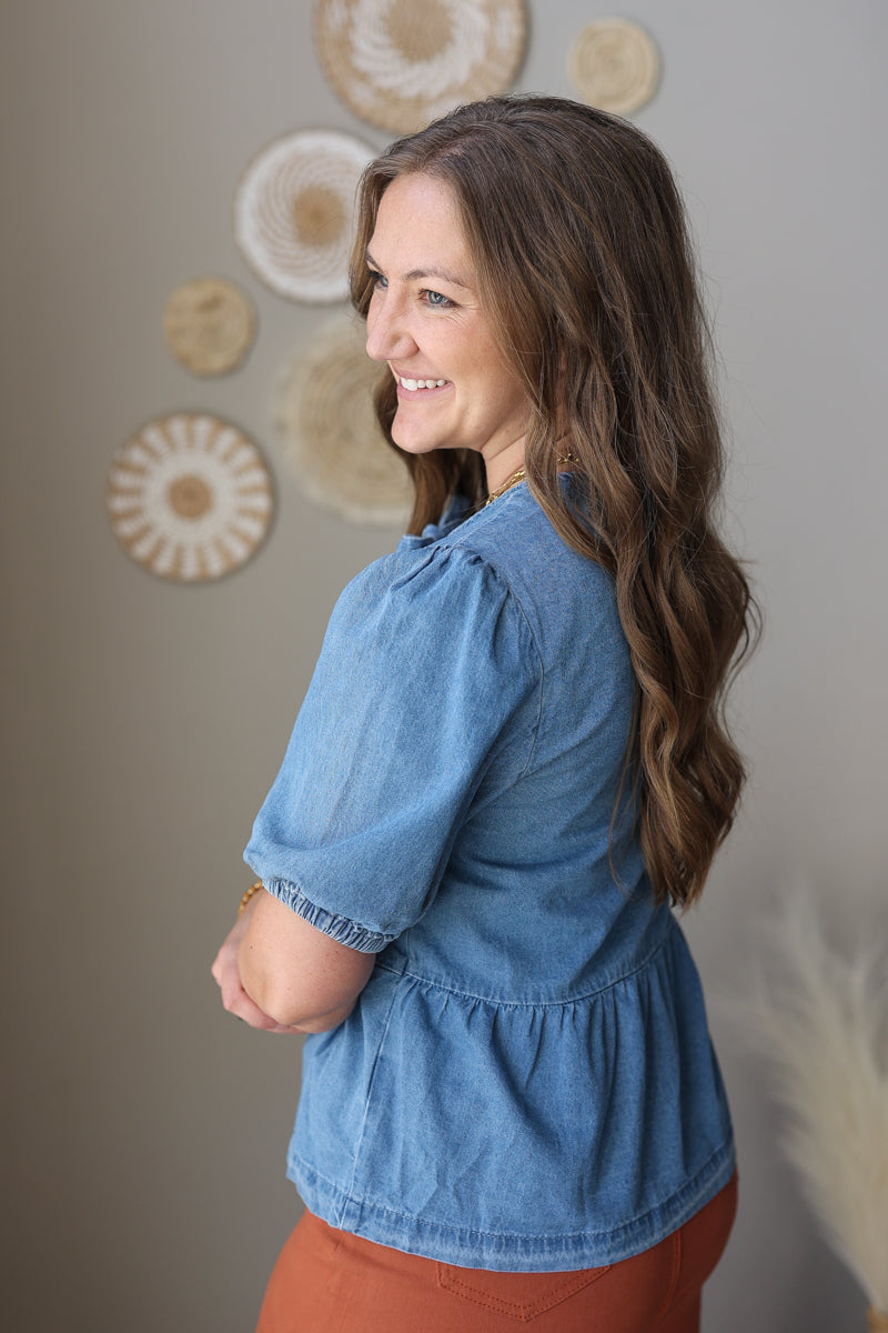 Woman wearing a blue blouse with a neutral background
