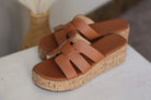 Brown platform sandals with cork sole on a white surface