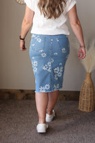 Person wearing a white floral denim skirt indoors