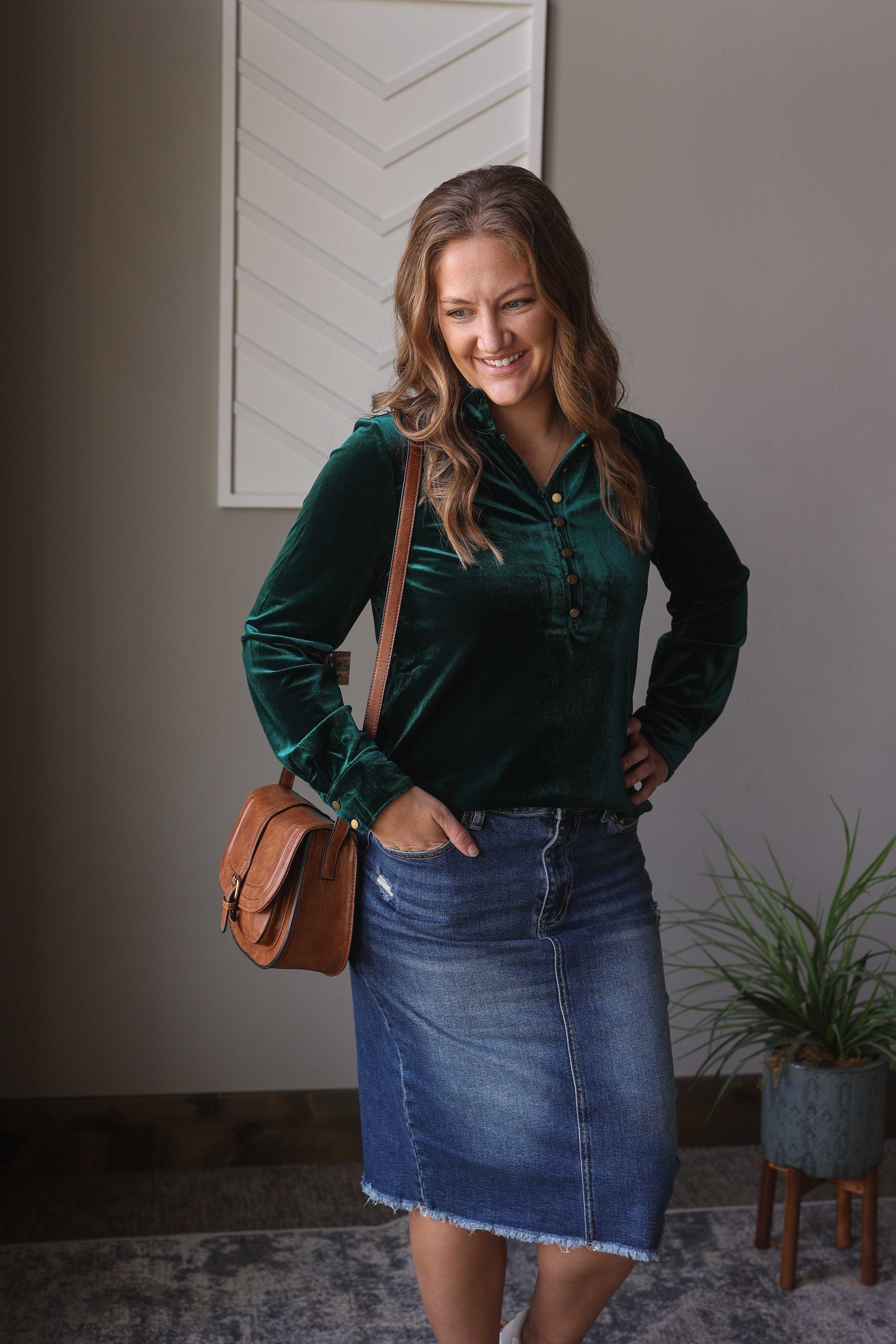 Feel stylish this holiday season with our beautiful Emerald Green Velvet Top. Experience luxurious comfort with its soft velvet texture and elevate your style with its elegant gold henley buttons. Perfect for any occasion, from holiday gatherings to work to date nights, this blouse is a must-have in your wardrobe. Classy Closet Hull Iowa, an online women's clothing boutique for modest, cute, trendy, and affordable holiday outfits!