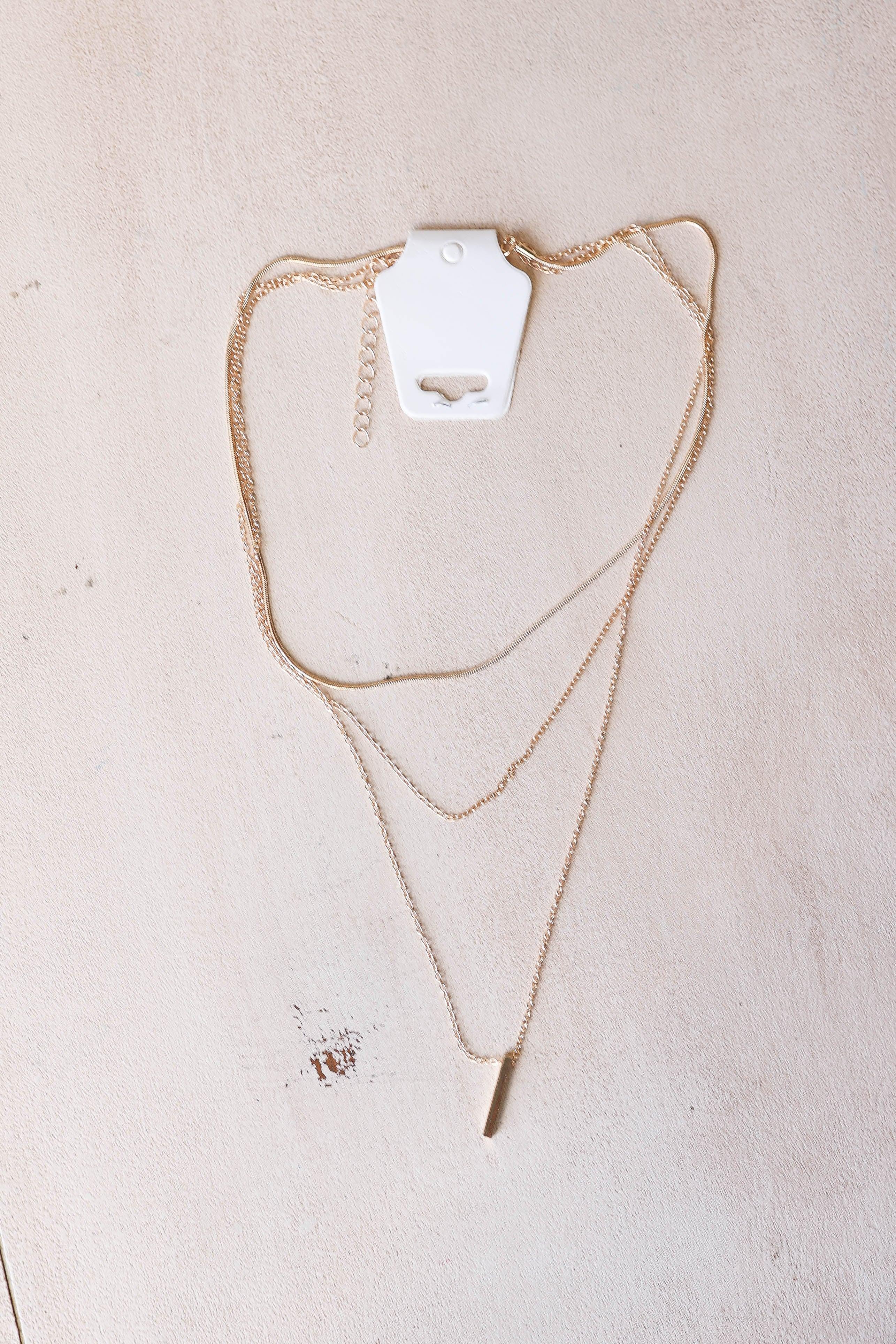 Add a touch of chic to any outfit with our Gold Bar Layered Necklace. Featuring a single gold bar and 3 layers, this cute and chic necklace is the perfect accessory for any fashion-loving mom. Feel confident in your style and make a statement with this layered necklace.
