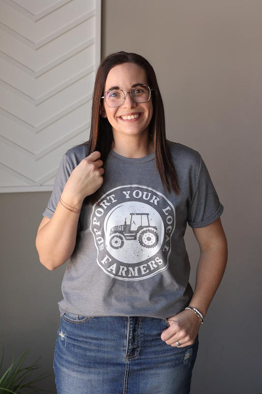 Show your love for local farmers with our Grey "Support Your Local Farmer" Tee. Featuring a fun and meaningful graphic, this shirt is perfect for anyone who appreciates family farms. Available in sizes S-2XL, grab yours now and show your support in your community! Classy Closet online women's clothing boutique for cute everyday chic outfits for 2025 summer outfits.
