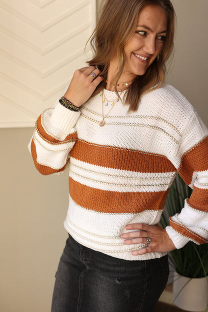 Stay warm and in style this season with this White Camel Balloon Sleeve Sweater. The camel and ivory stripes with a hint of gold make this the perfect versatile sweater for any occasion. Cozy and chic, you'll look fashionable and stylish in all your winter outfits! Classy CLoset Online Women's Trendy Boutique CLothing