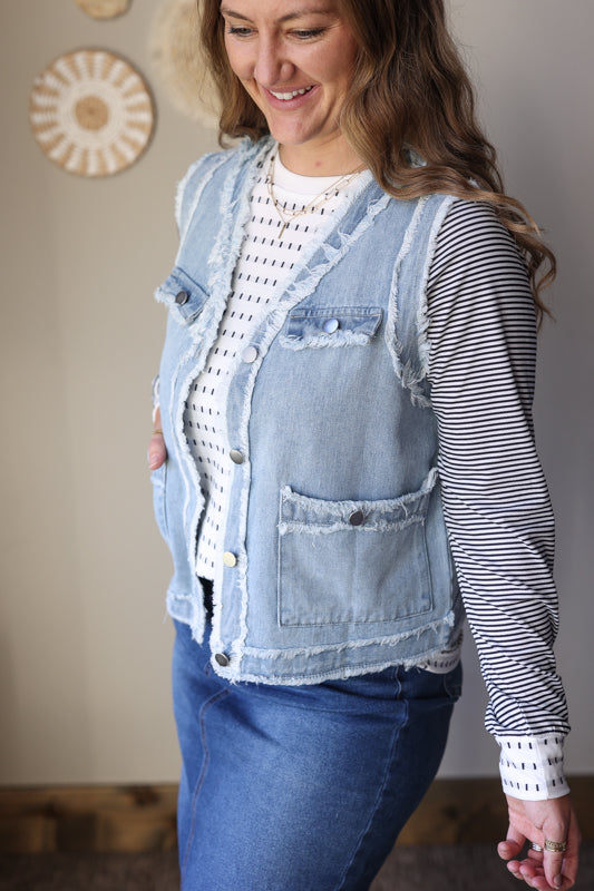 Women’s black striped raglan sleeve top paired with a modest denim skirt and denim vest