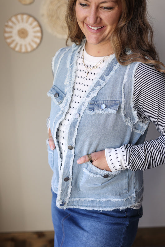 Frayed edge denim vest jacket with flap pockets styled in a casual outfit