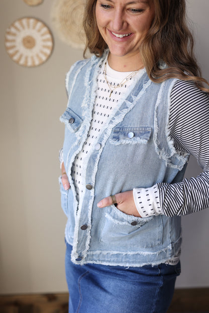 Frayed edge denim vest jacket with flap pockets styled in a casual outfit