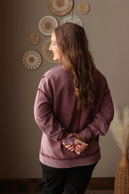 Woman wearing Burgundy Mineral Wash Side Slit Sweatshirt with relaxed fit, styled casually with joggers, perfect for comfortable everyday wear for spring outfits