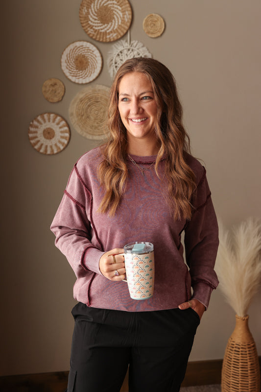 Woman wearing Burgundy Mineral Wash Side Slit Sweatshirt with relaxed fit, styled casually with joggers, perfect for comfortable everyday wear