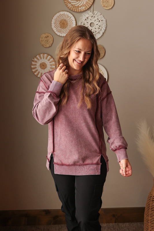 Woman wearing Burgundy Mineral Wash Side Slit Sweatshirt with relaxed fit, styled casually with joggers, perfect for comfortable everyday wear