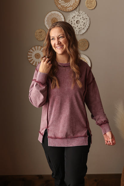 Woman wearing Burgundy Mineral Wash Side Slit Sweatshirt with relaxed fit, styled casually with joggers, perfect for comfortable everyday wear