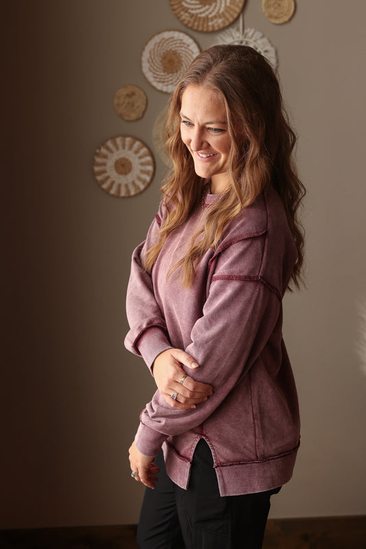 Woman wearing Burgundy Mineral Wash Side Slit Sweatshirt with relaxed fit, styled casually with joggers, perfect for comfortable everyday wear