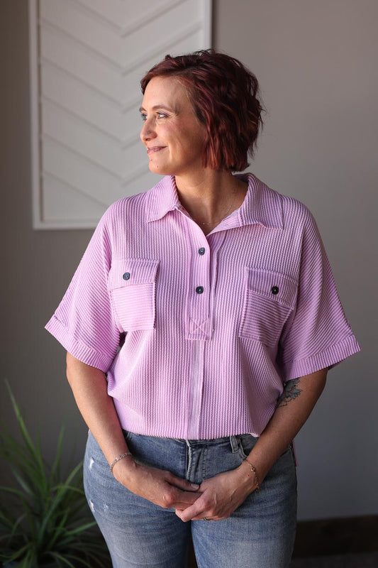 This fun and cheerful Lavender Corded Flap Pocket Top is both stylish and comfortable, with an oversized fit and charming details such as the seam details, henley v-neck button, and collar details. It's perfect for everyday wear, casual work outfits, and even coffee dates. Classy Closet online boutique for women's clothing in Hull iowa. Modest fashion for everyday chic moms and easy cute outfits in 2025. 