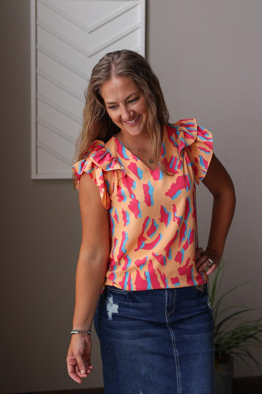 Stay cool and stylish this summer with our Orange Abstract Print Top. Its vibrant colors and chic ruffle flutter sleeves make it perfect for any occasion. Dress it up for the office, a day out with the girls, or date night. Stay effortlessly chic and put-together all day long. Classy Closet online women's boutique near me hull iowa rock valley iowa