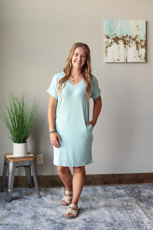 Front view of sage green v-neck  summer midi dress with rolled up sleeves, perfect for everyday summer casual style at Classy Closet, a women's online modest boutique store.