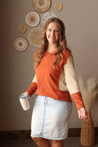 Colorblock sleeve v-neck hooded top in chestnut orange styled for a modest outfit paired with light wash denim skirt knee length for modest fashion