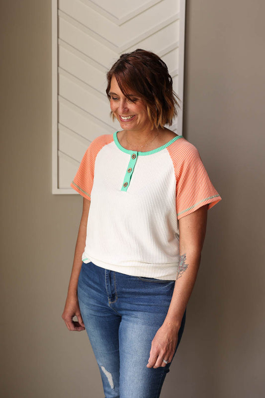 Elevate your summer style with our White Colorblock Textured Henley Top. Featuring vibrant green and coral trim details, this top adds a fun pop of color to any outfit. The lightweight, textured fabric keeps you cool and comfortable all day long. Available in sizes S-2XL PLUS. Classy Closet Everyday Chic Style