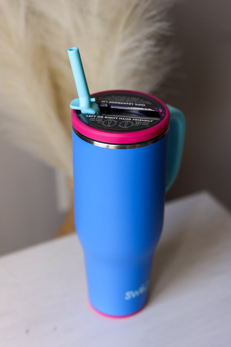 Blue insulated mug with pink lid and straw on a white surface SWIG Berry Blast 40oz mega mug with handle